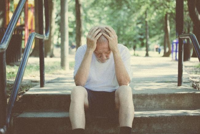 אדם מבוגר יושב עצוב בגן ציבורי ותופס את ראשו בגלל תחושת בדידות שנקשרה לאחרונה כגורם סיכון לסוכרת סוג 2